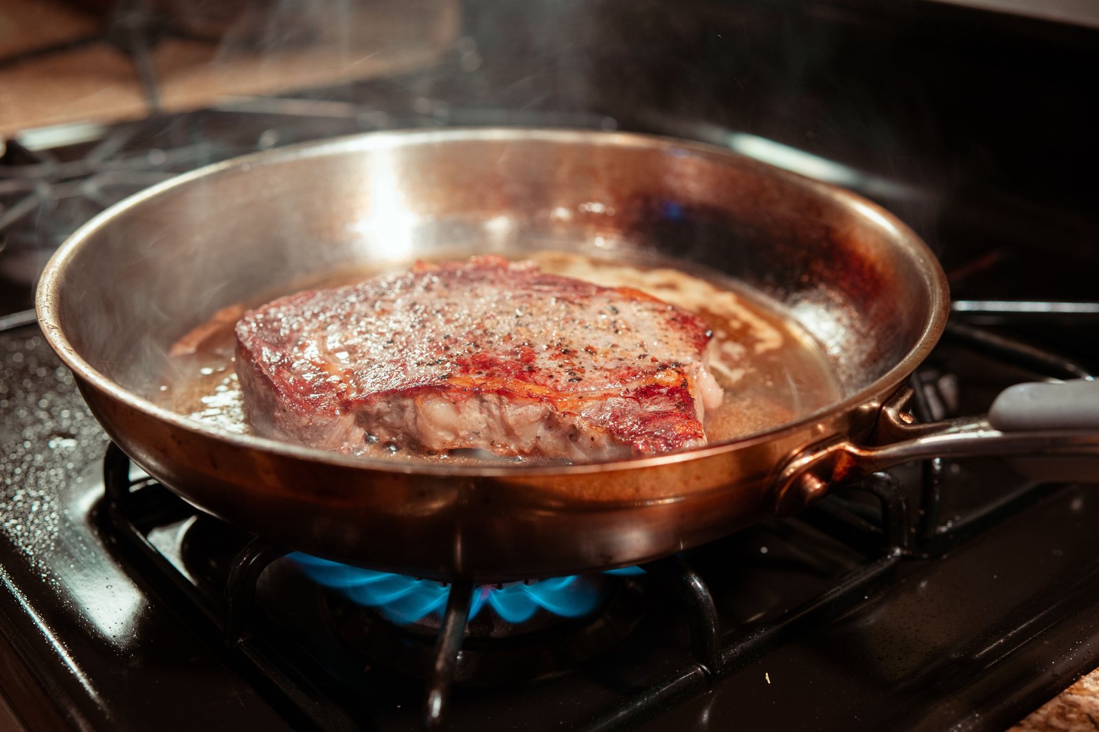 Fleisch wird in einer heißen Pfanne angebraten
